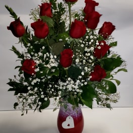 Red roses arranged in a vase with white baby's breath