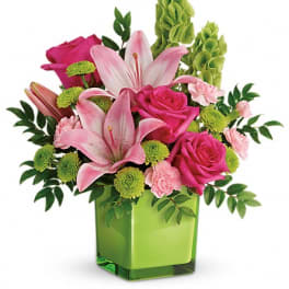 Pink lilies and roses in a green square vase