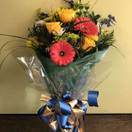 Mixed bouquet with yellow roses and pink gerbera daisies in clear wrap
