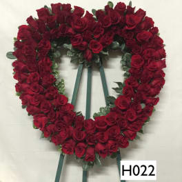 Heart-shaped wreath of red roses on a stand