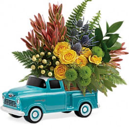 Yellow roses arranged in a turquoise toy pickup truck