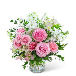 Pink roses and white flowers arranged in a clear glass vase