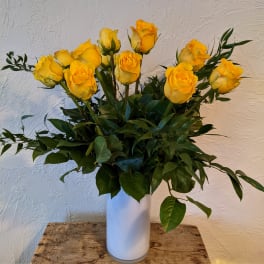 Yellow roses arranged in a white vase