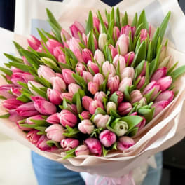 Large bouquet of pink tulips wrapped in pale paper