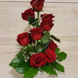 Tall arrangement of red roses in a clear glass vase
