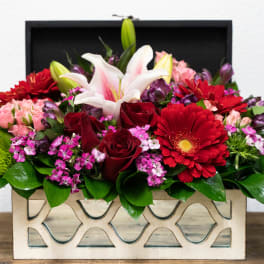 Mixed bouquet in a decorative rectangular box with red, pink, and white blooms