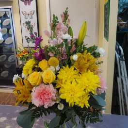 Mixed bouquet with yellow chrysanthemums, roses, lilies, and pink flowers