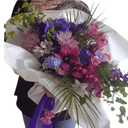 Bouquet of purple, pink, and blue flowers wrapped in white paper