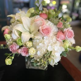 Bouquet of pink roses, white lilies, and white hydrangeas in a vase