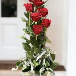 Tall arrangement of red roses in a silver vase