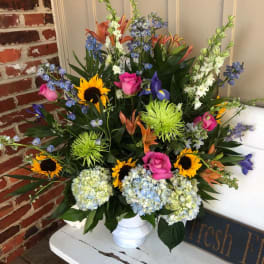 Colorful mixed flower arrangement in a white vase