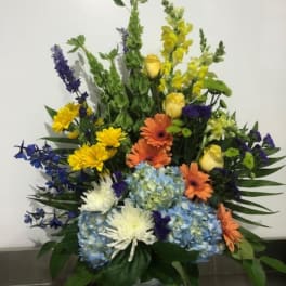 Colorful mixed flower arrangement in a white vase