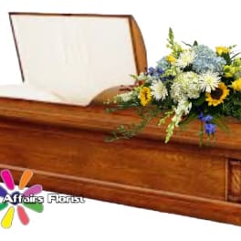 Wooden casket with a mixed floral spray on top