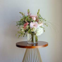 Pink and white flower arrangement in a clear glass vase