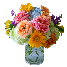Colorful bouquet of gerbera daisies, hydrangeas, and roses in a glass vase