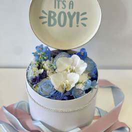 Round box of blue and white flowers with an "It's a Boy!" topper