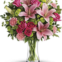 Pink lilies and roses in a clear glass vase