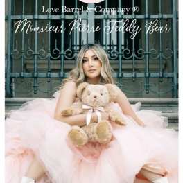 Woman in a pink dress holding a teddy bear with brand text overlaid