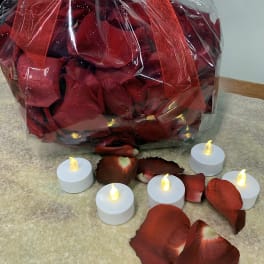Bag of red rose petals with small LED tealight candles