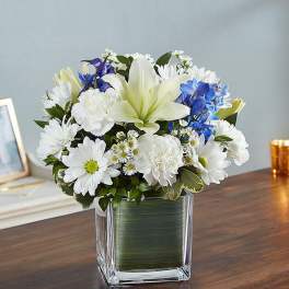 White lilies and daisies in a square glass vase