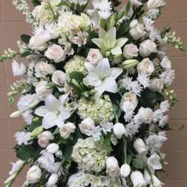 Large white funeral spray with lilies, roses, and hydrangeas