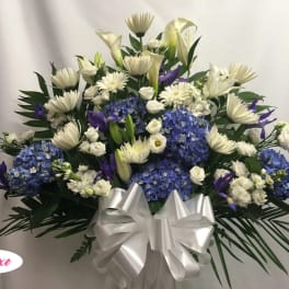 White and blue floral arrangement with a large silver bow