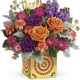 Colorful bouquet with orange roses and purple flowers in a yellow box