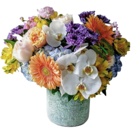 Mixed bouquet with orchids, gerbera daisies, roses, and hydrangeas in a textured vase