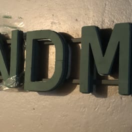 Wall sign spelling GRANDMA in dark green letters