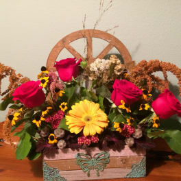 Mixed bouquet with red roses and a yellow gerbera daisy in a decorative box