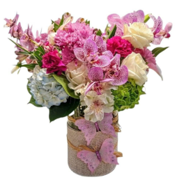 Pink and white mixed bouquet in a burlap-wrapped vase with butterfly decorations