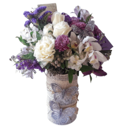 Bouquet of white roses, purple flowers, and orchids in a wrapped vase