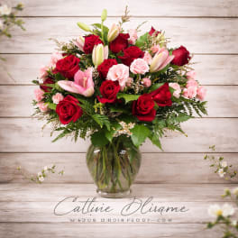 Bouquet of red and pink roses with lilies in a glass vase