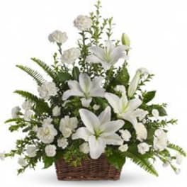 White lilies and carnations arranged in a wicker basket