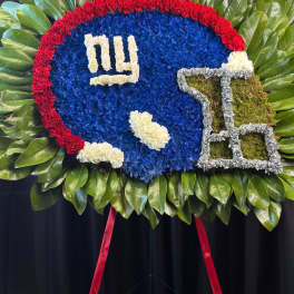 Football-shaped floral tribute with a red border and blue center