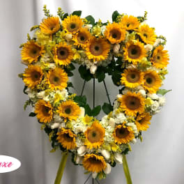 Heart-shaped sunflower wreath on a stand with white flowers