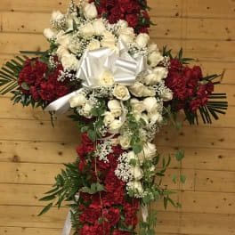 Cross-shaped floral tribute with white roses and red carnations
