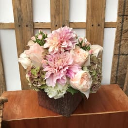 Pink and cream floral arrangement in a textured brown vase