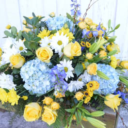 Bouquet of yellow roses, blue hydrangeas, and white daisies