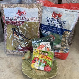Bird food bags and suet cakes arranged on the floor