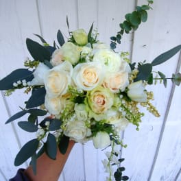 Handheld bouquet of white roses and pale blooms with dark foliage