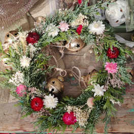 Floral wreath with red, pink, and white blooms and gold bells