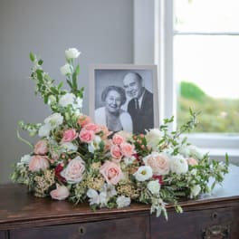 Pastel floral arrangement with a framed black-and-white portrait