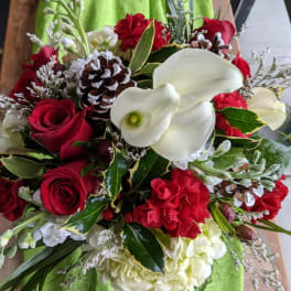 Bouquet of red roses, white calla lilies, and pinecones
