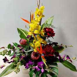 Tropical bouquet with yellow orchids, purple orchids, and red blooms