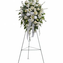 White floral standing spray on a black easel with ribbon