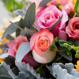 Bouquet of pink roses with yellow sunflowers and gray-green foliage