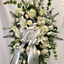 White floral standing spray with a large silver ribbon
