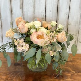 Peach and cream bouquet in a clear glass vase