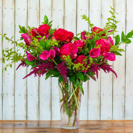 Pink roses and calla lilies in a clear glass vase